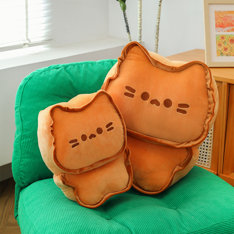 Biscuit Cat Plush Pillows in two sizes displayed on a lounge chair, featuring a cute biscuit-inspired cat design and soft plush fabric for cozy home décor and everyday comfort