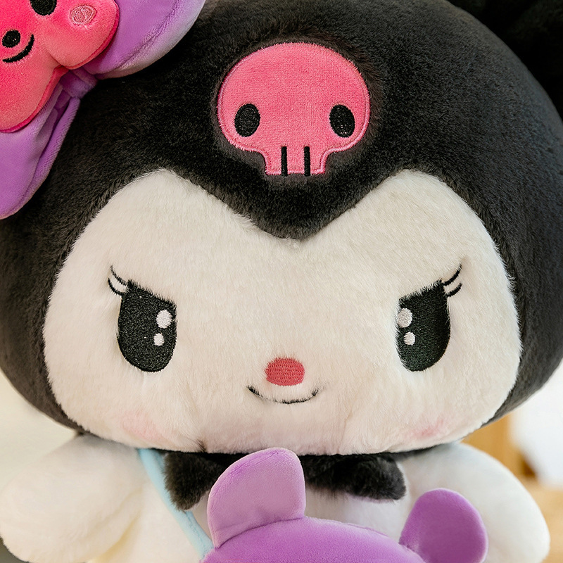 Close-up of the Kuromi plush toy featuring embroidered facial details, signature pink skull emblem, and soft plush fabric