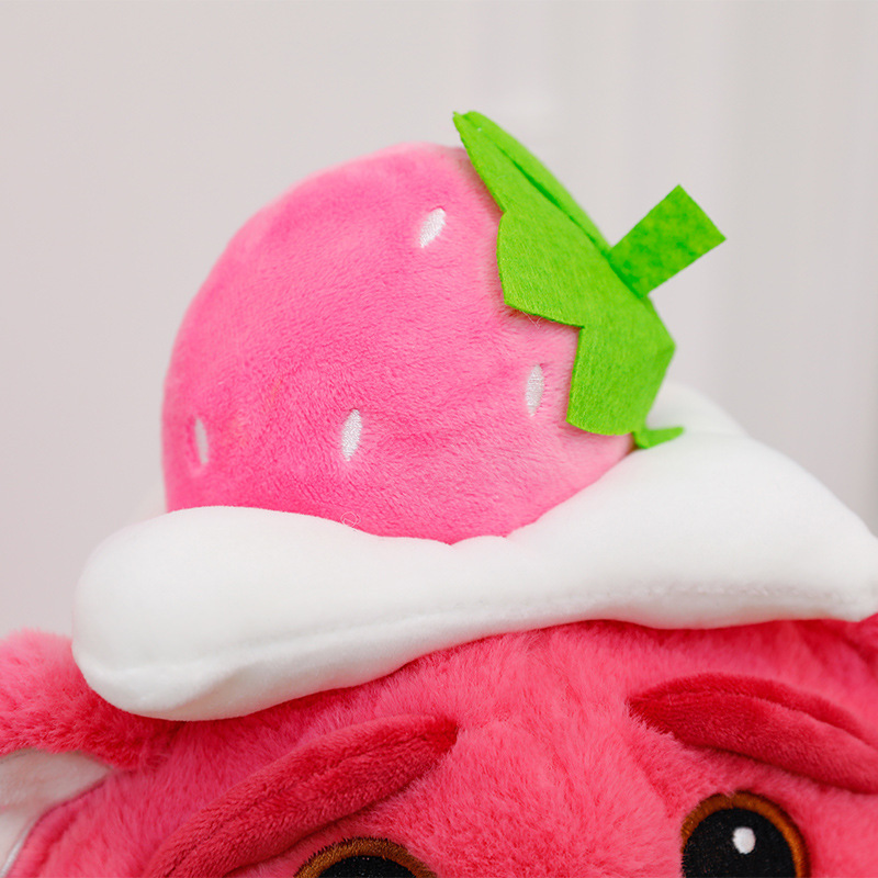 Close-up of the strawberry hat on the Pink Bear Plush Toy, showcasing soft plush fabric and embroidered leaf and seed details