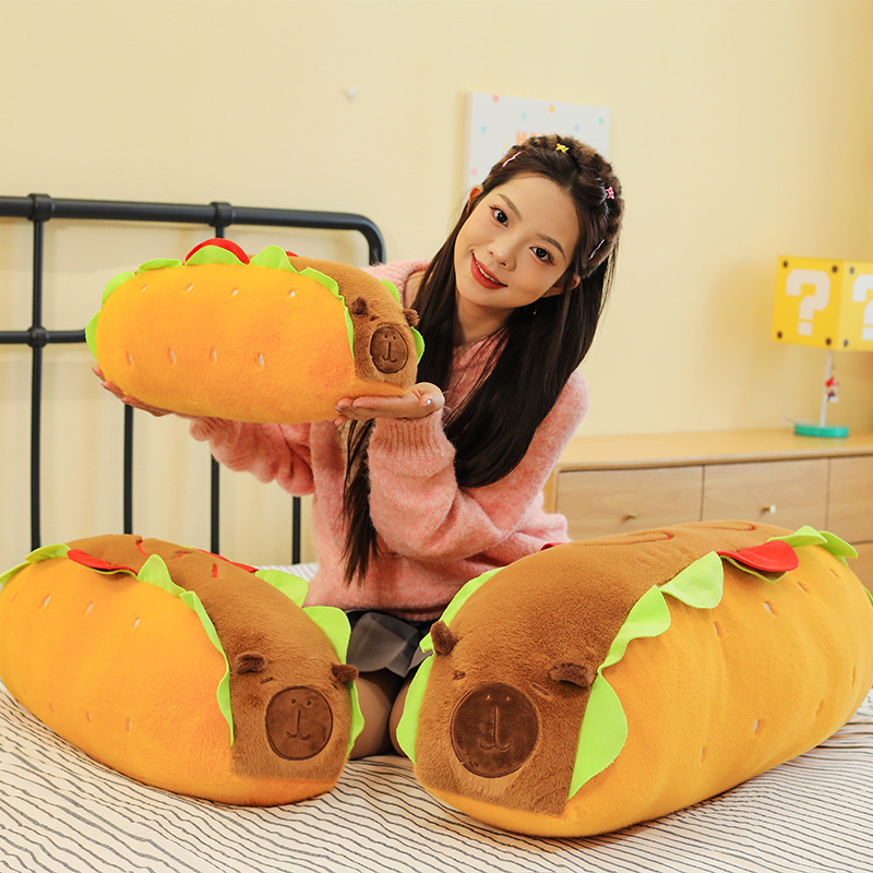 Hot Dog Capybara Plush Pillow displayed on a bed, showcasing its soft plush fabric, playful food-inspired design, and cozy look for bedrooms and relaxing spaces