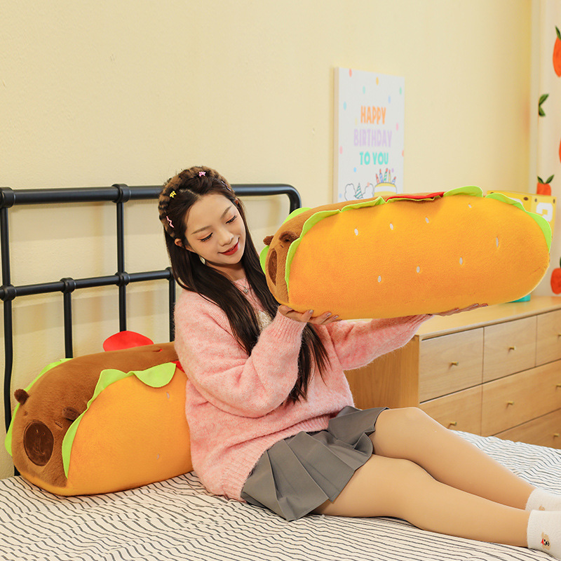 Hot Dog Capybara Plush Pillow in a cozy bedroom setting, highlighting its long body design for hugging, lounging, reading, and everyday relaxation
