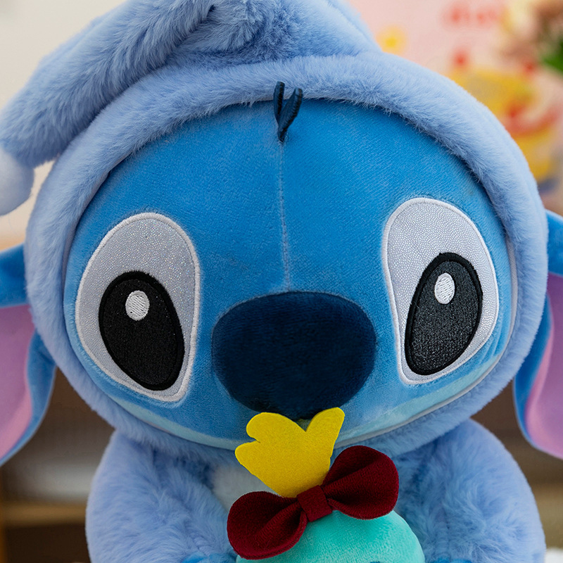 Close-up of the Stitch Costume Plush Toy featuring embroidered facial details, soft plush fabric, and a plush Scrump doll accessory