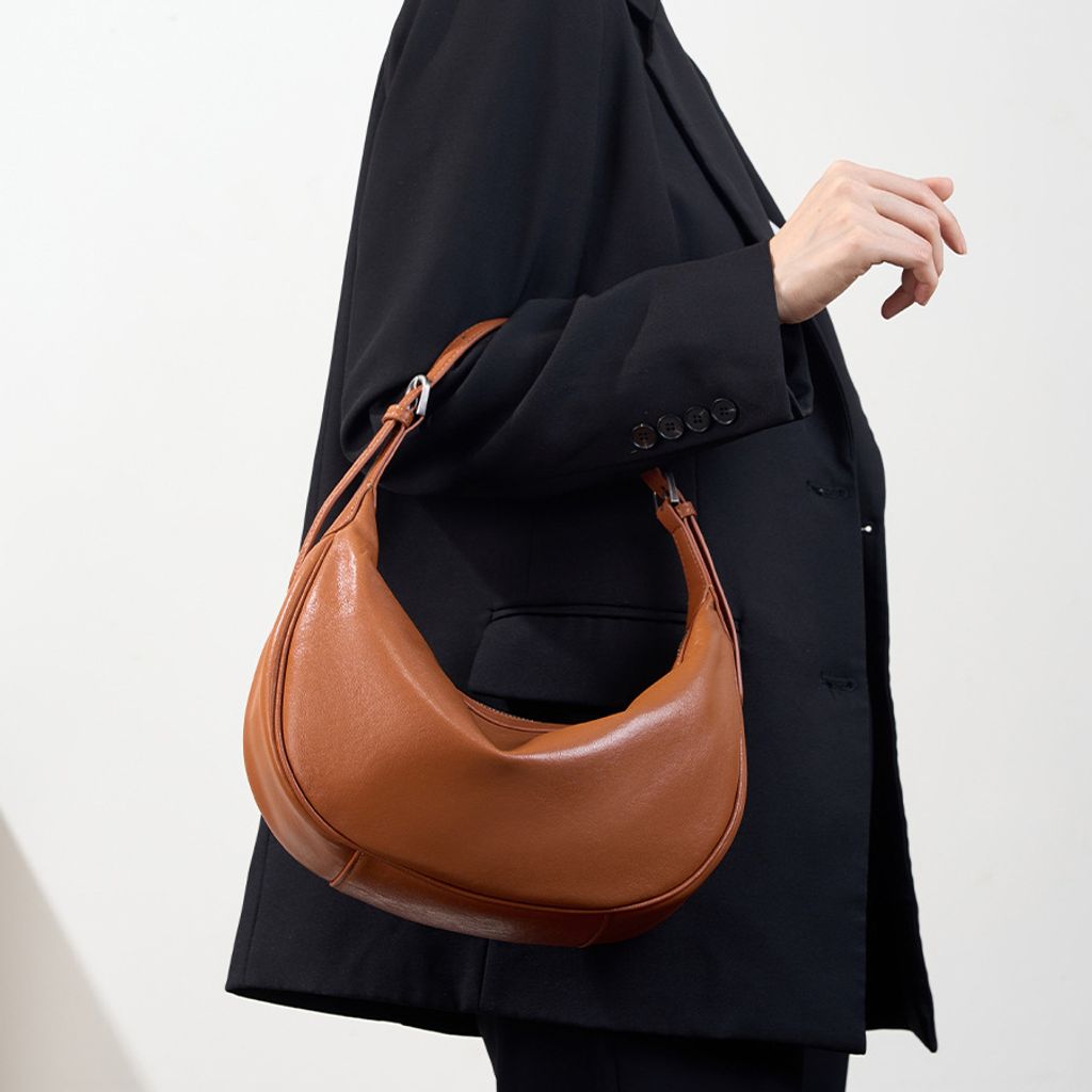Model carrying Luna Genuine Leather Hobo Bag in Caramel – top handle style
