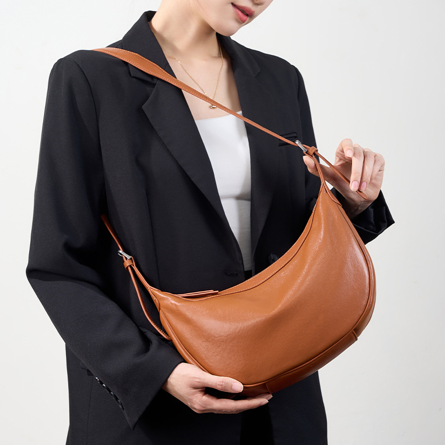 Model carrying Luna Leather Hobo Bag in Caramel – on shoulder