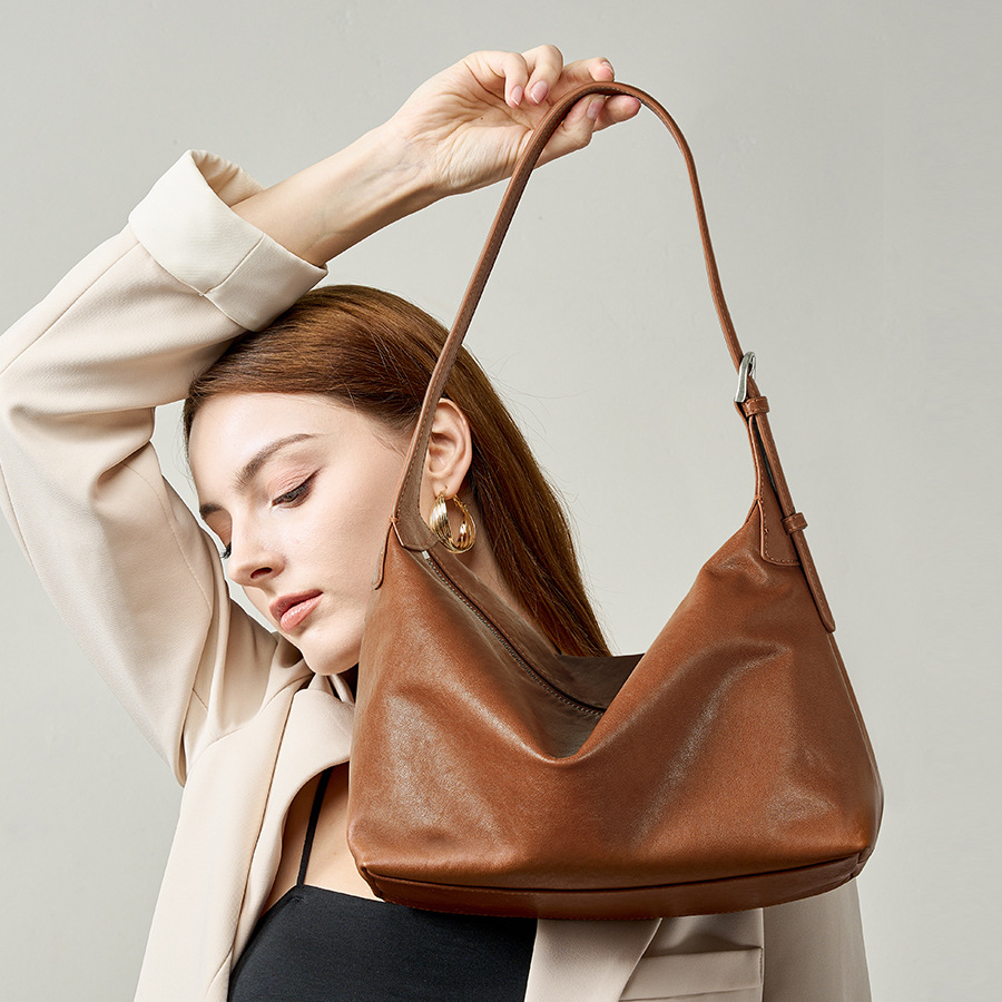 Model carrying Classic Leather Hobo Bag in Walnut – top handle style