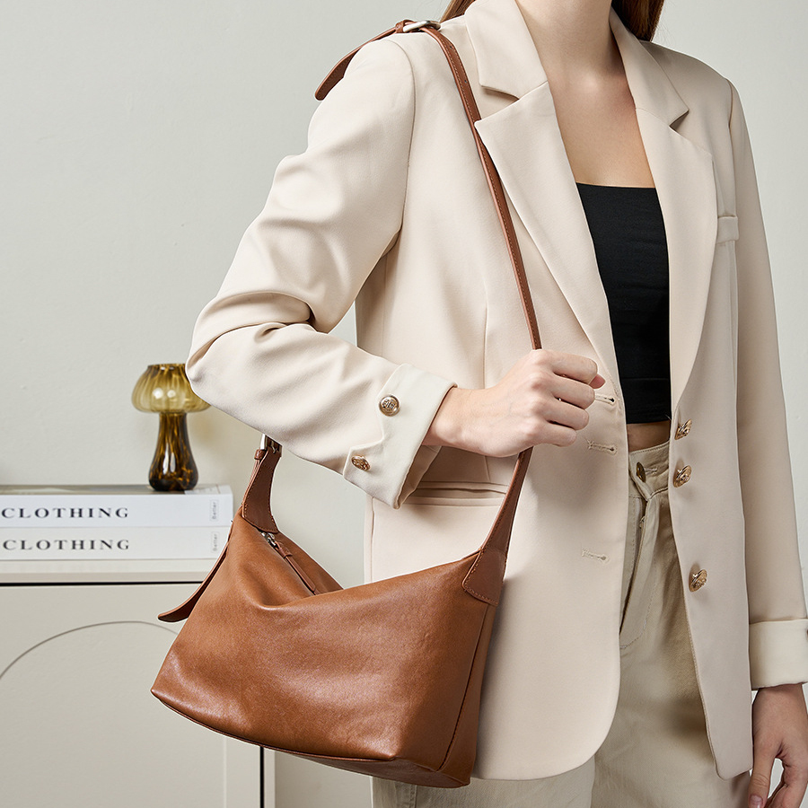Model carrying Classic Leather Hobo Bag in Walnut – on shoulder
