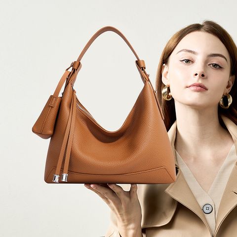 Model showcasing Chic Luxury Genuine Leather Hobo Bag in Golden Brown