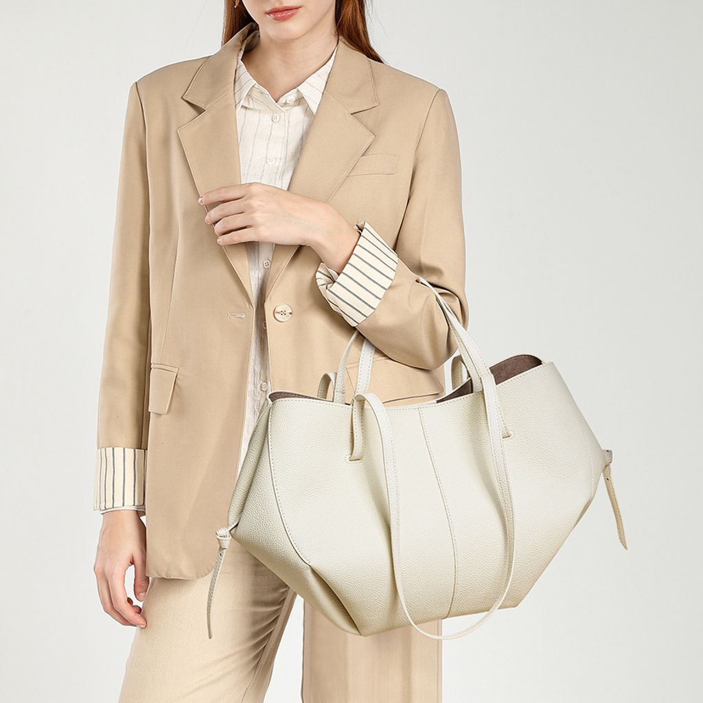 Model carrying Urban Commuter Genuine Leather Tote Bag in White – carried in crook of arm