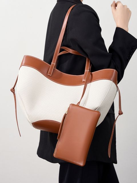Model showcasing Wing Curve Genuine Leather Tote Bag in Brown