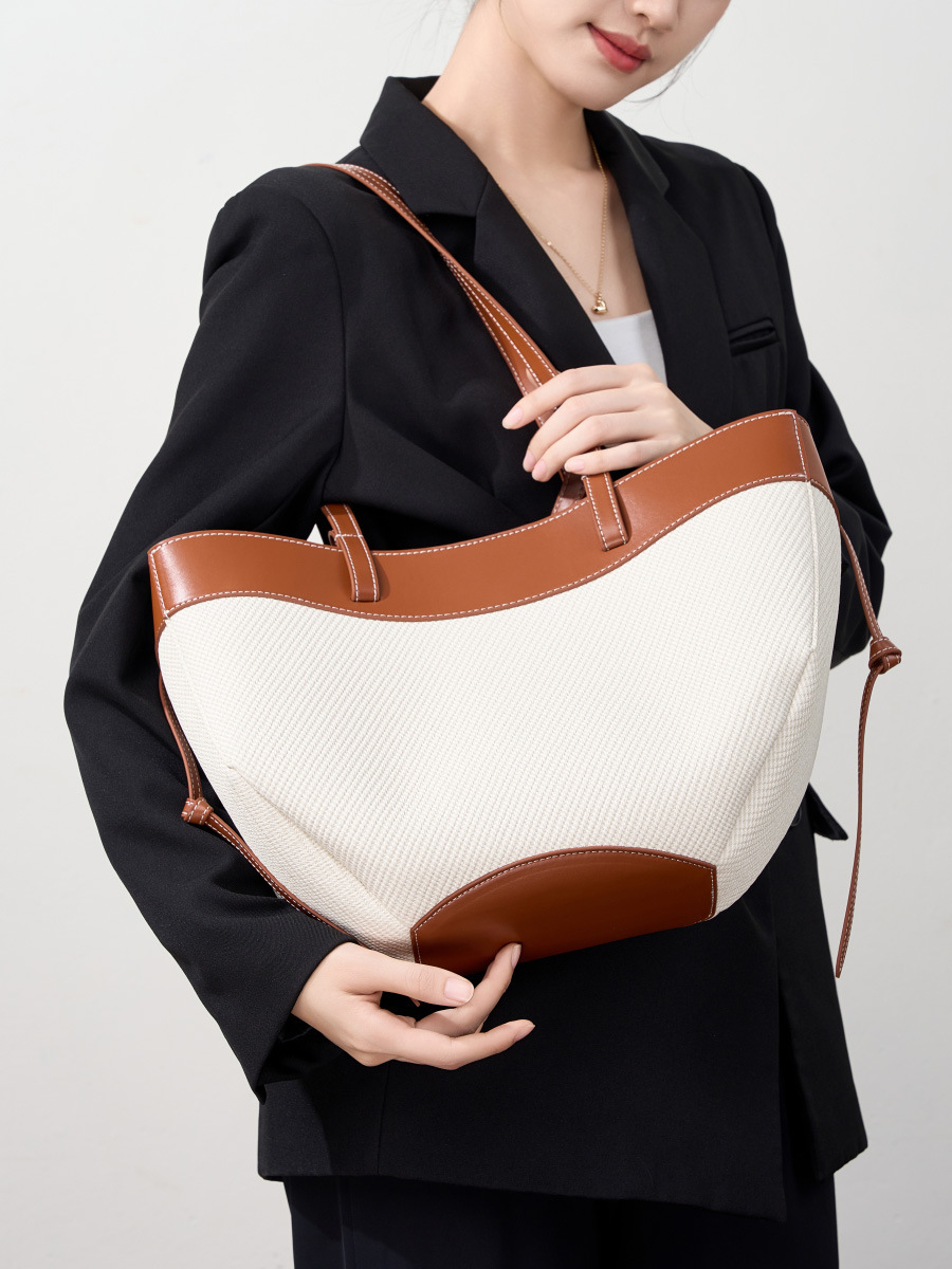 Model showcasing Wing Curve Leather Tote Bag in Brown – on shoulder