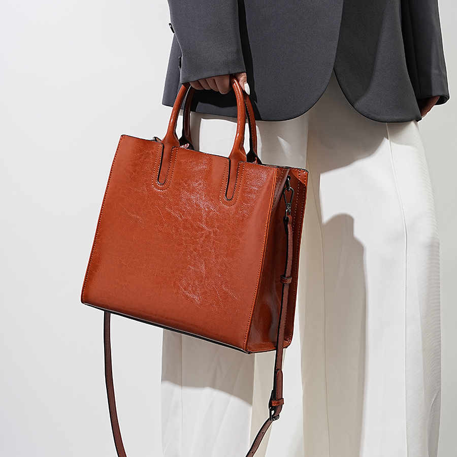 Model showcasing Premium Leather Top Handle Tote Bag in Caramel