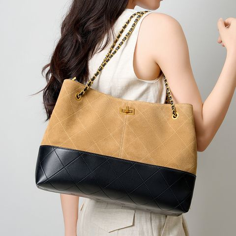 Model showcasing Premium Genuine Leather Two-Tone Chain Bucket Bag in Brown