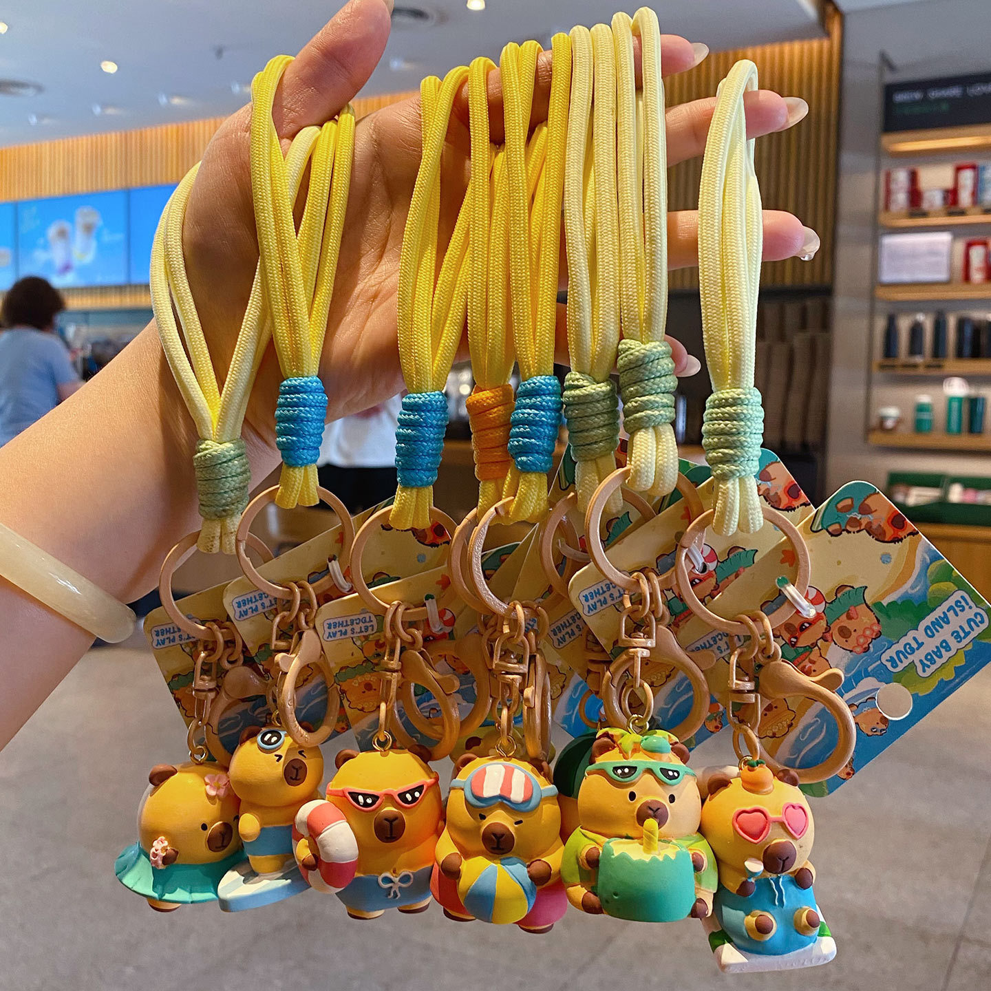 Cute capybara island tour keychain charms showing multiple designs