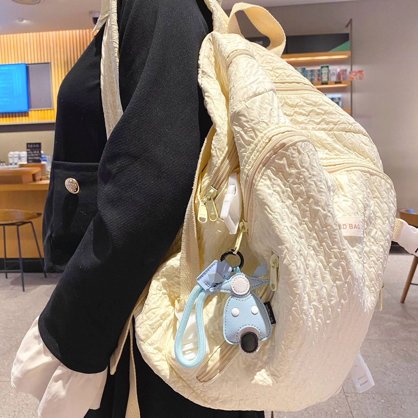 Motorcycle keychain charm hanging on a bag