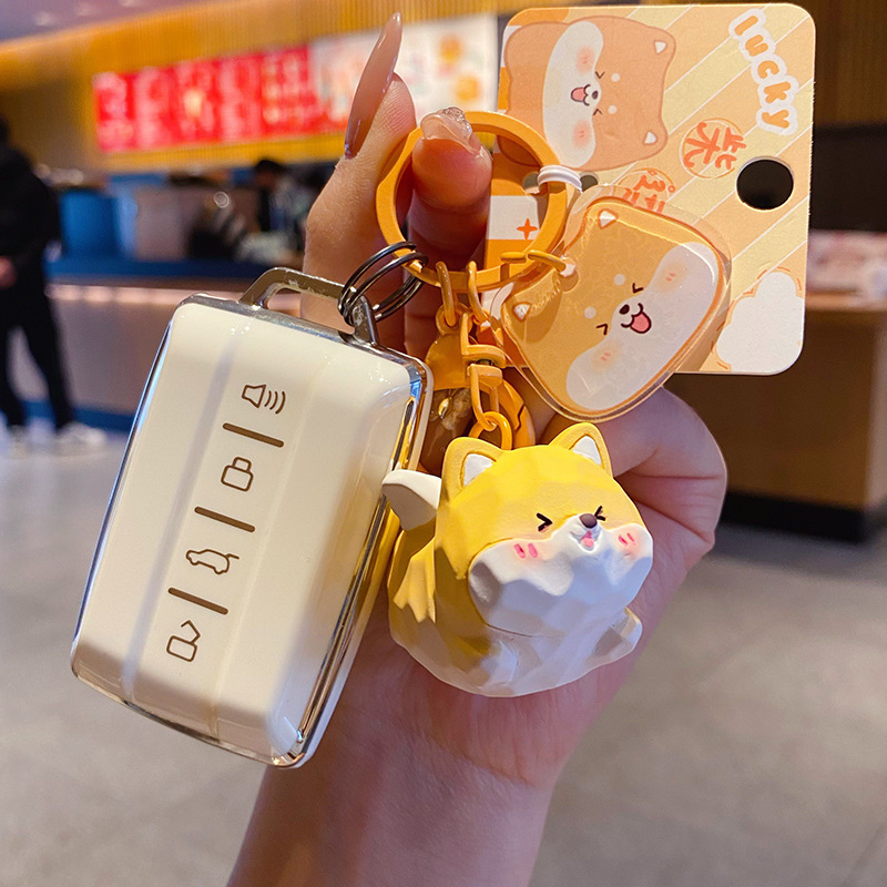 Flying Shiba Inu keychain charm attached to a car key fob