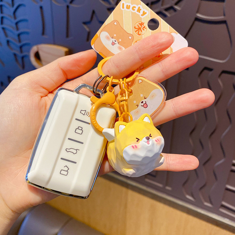 Flying Shiba Inu keychain charm attached to a car key fob