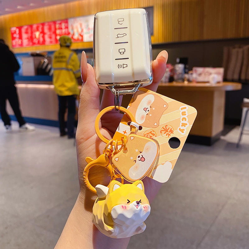 Flying Shiba Inu keychain charm attached to a car key fob