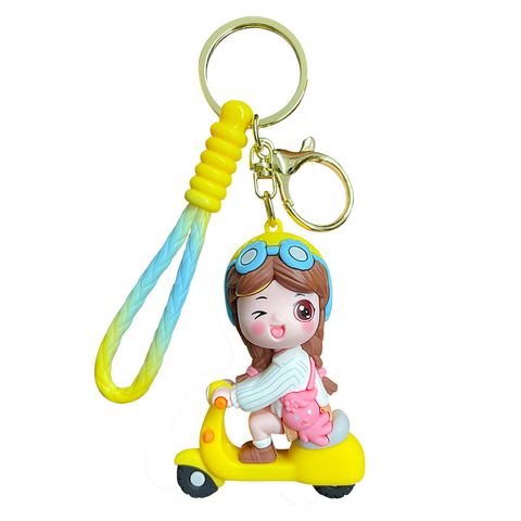 Electric scooter girl keychain charm in yellow on white background
