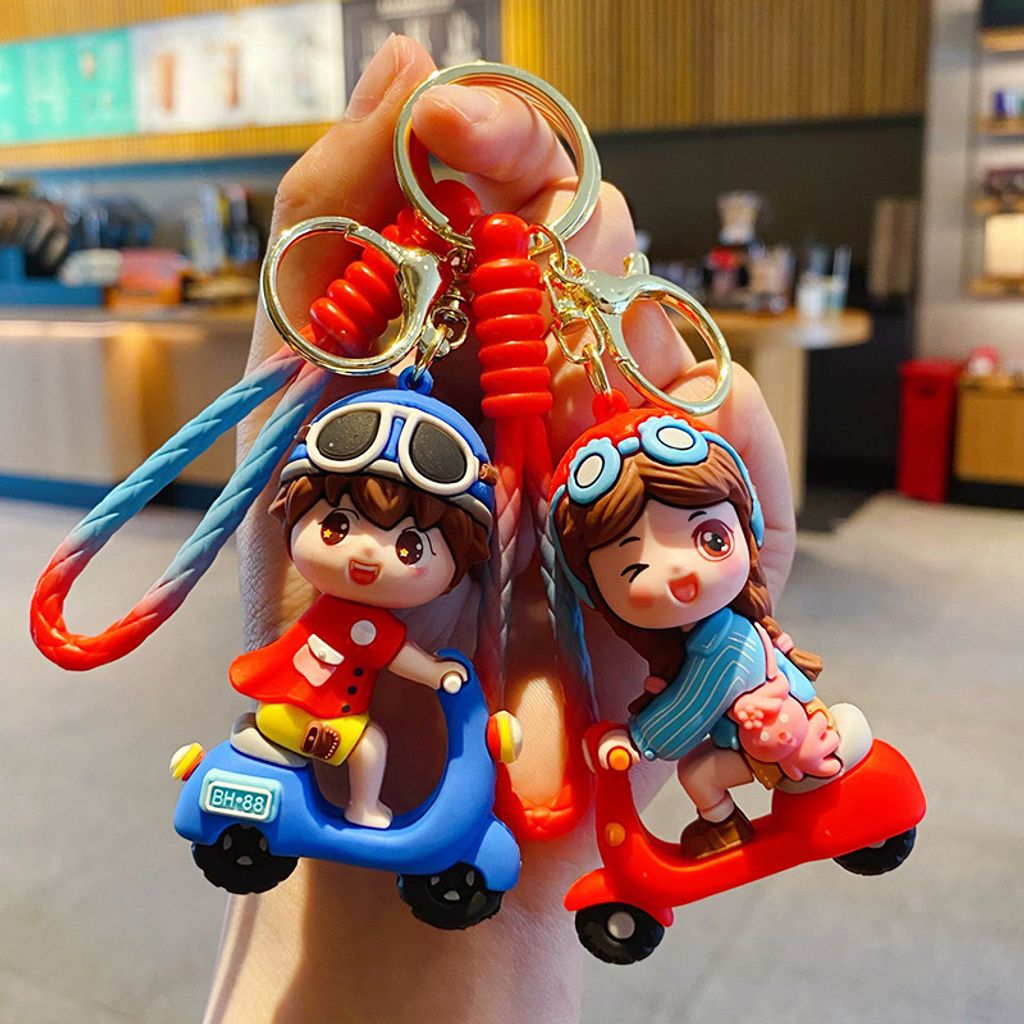 Electric scooter boy in blue and girl in red keychain charms
