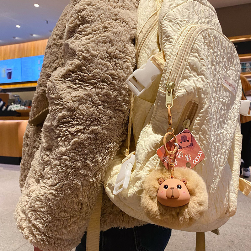 Capybara pom pom keychain charm hanging on a bag