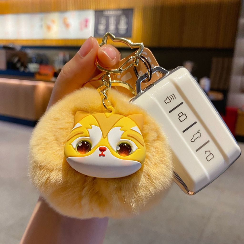 Golden British Shorthair Cat pom pom keychain charm attached to a car key fob