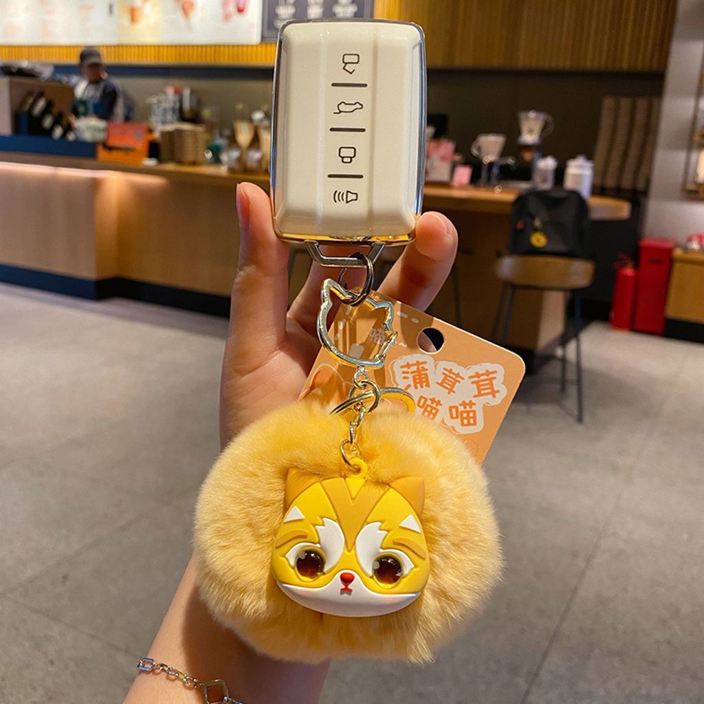 Golden British Shorthair Cat pom pom keychain charm attached to a car key fob