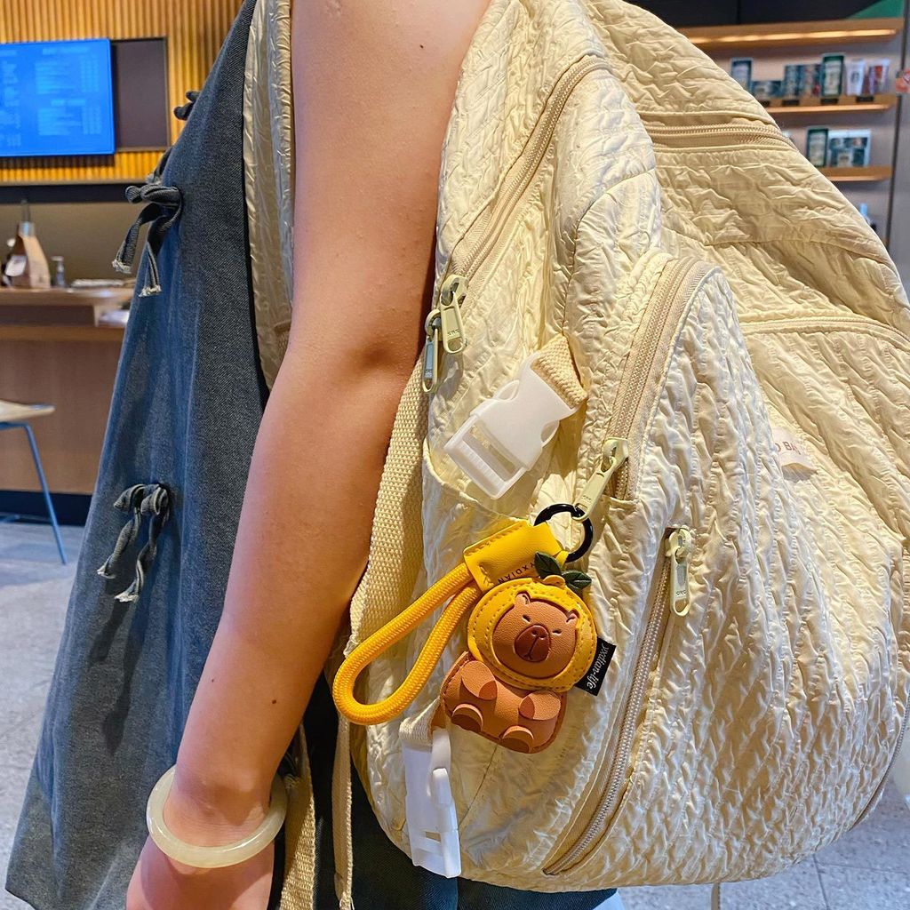 Cute leather capybara keychain charm hanging on a bag