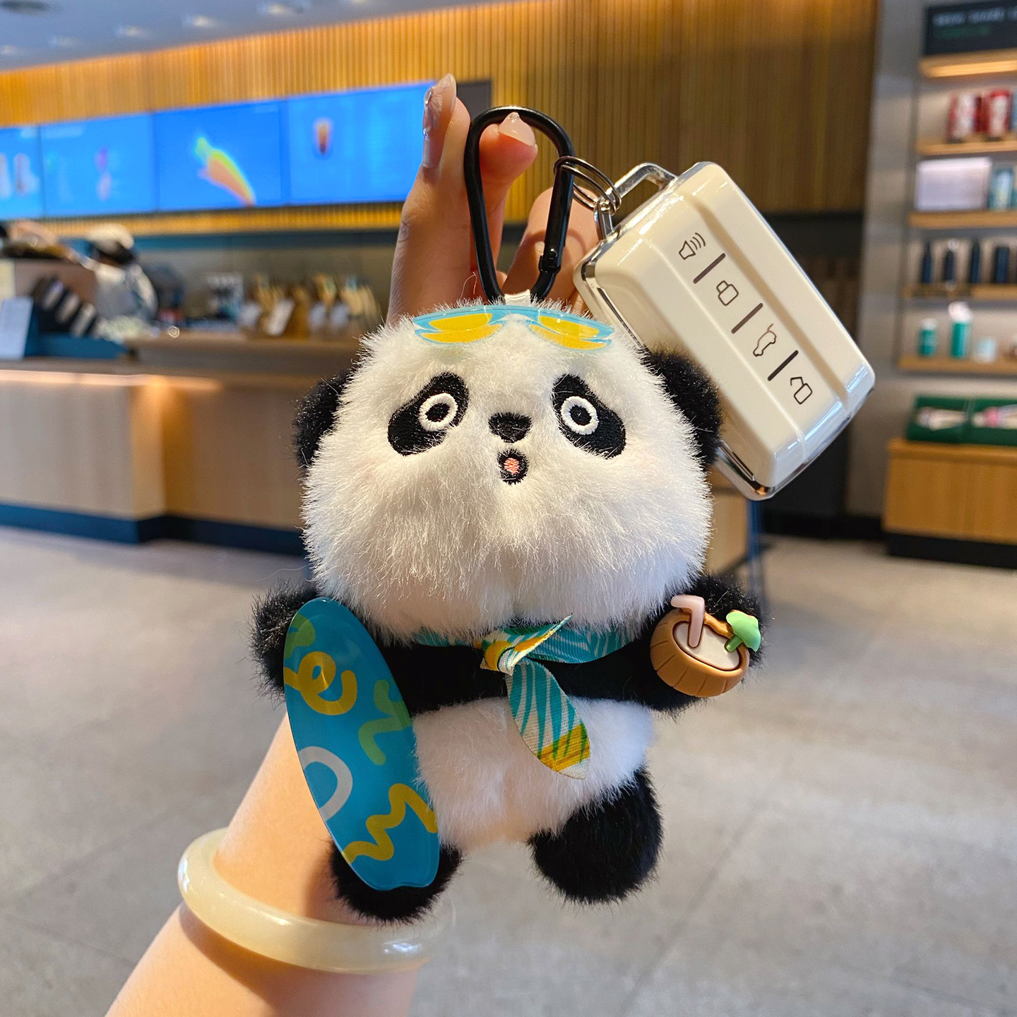 Panda plush skateboard keychain charm attached to a car key fob