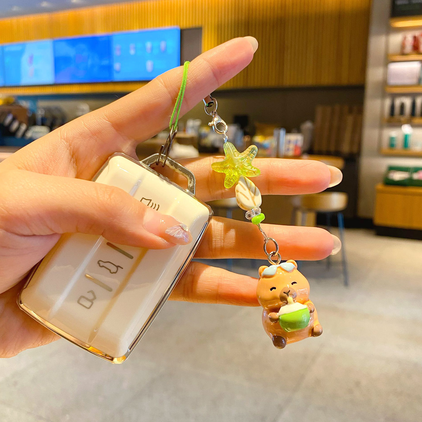 Beach capybara beaded keychain charm attached to a car key fob