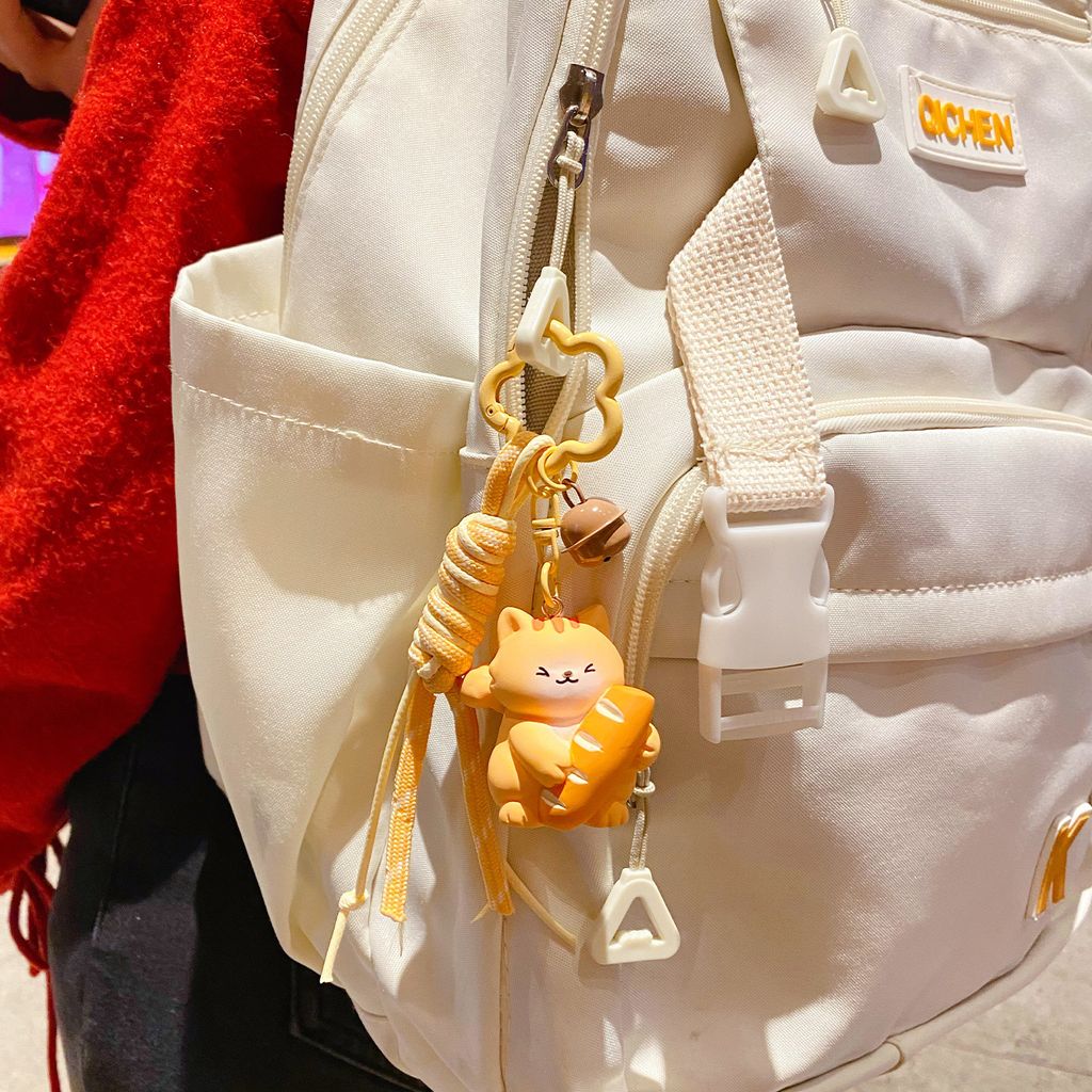 Cute bread cat keychain charm hanging on a bag