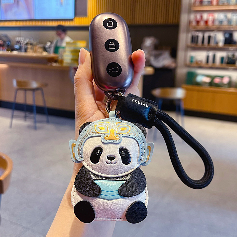 Panda leather keychain charm with Sanxingdui mask design attached to a car key fob