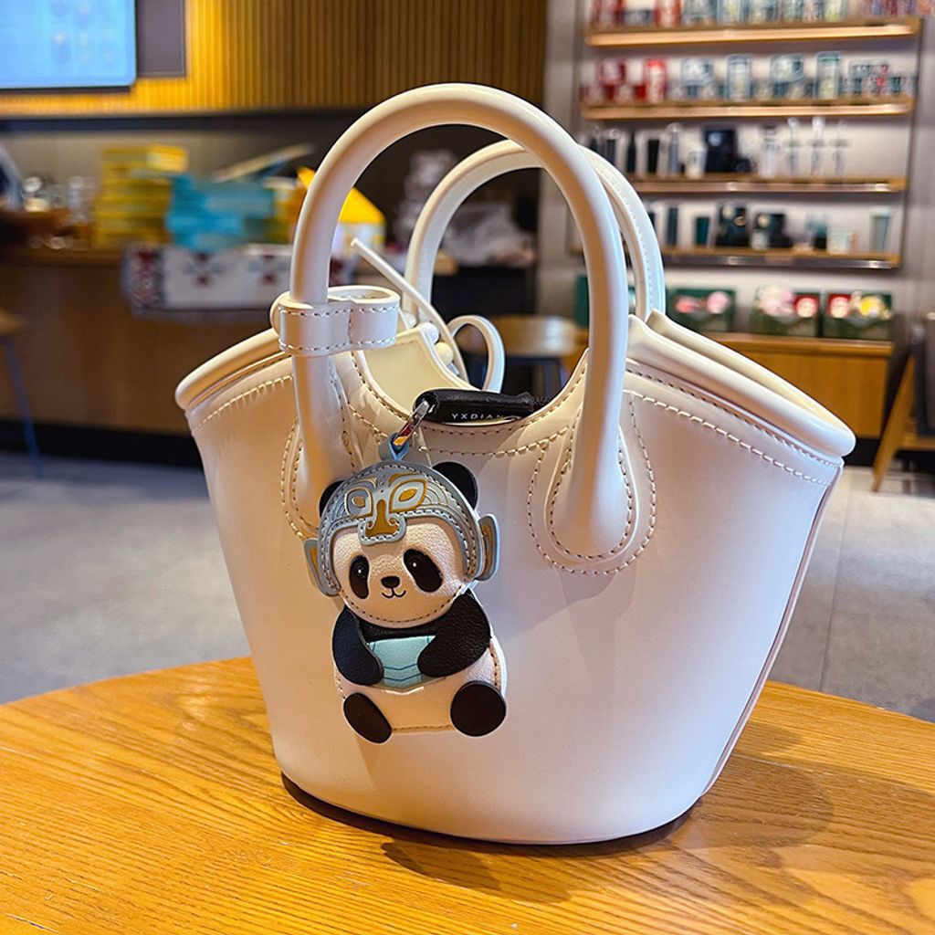 Panda leather keychain charm with Sanxingdui mask design hanging on a bag