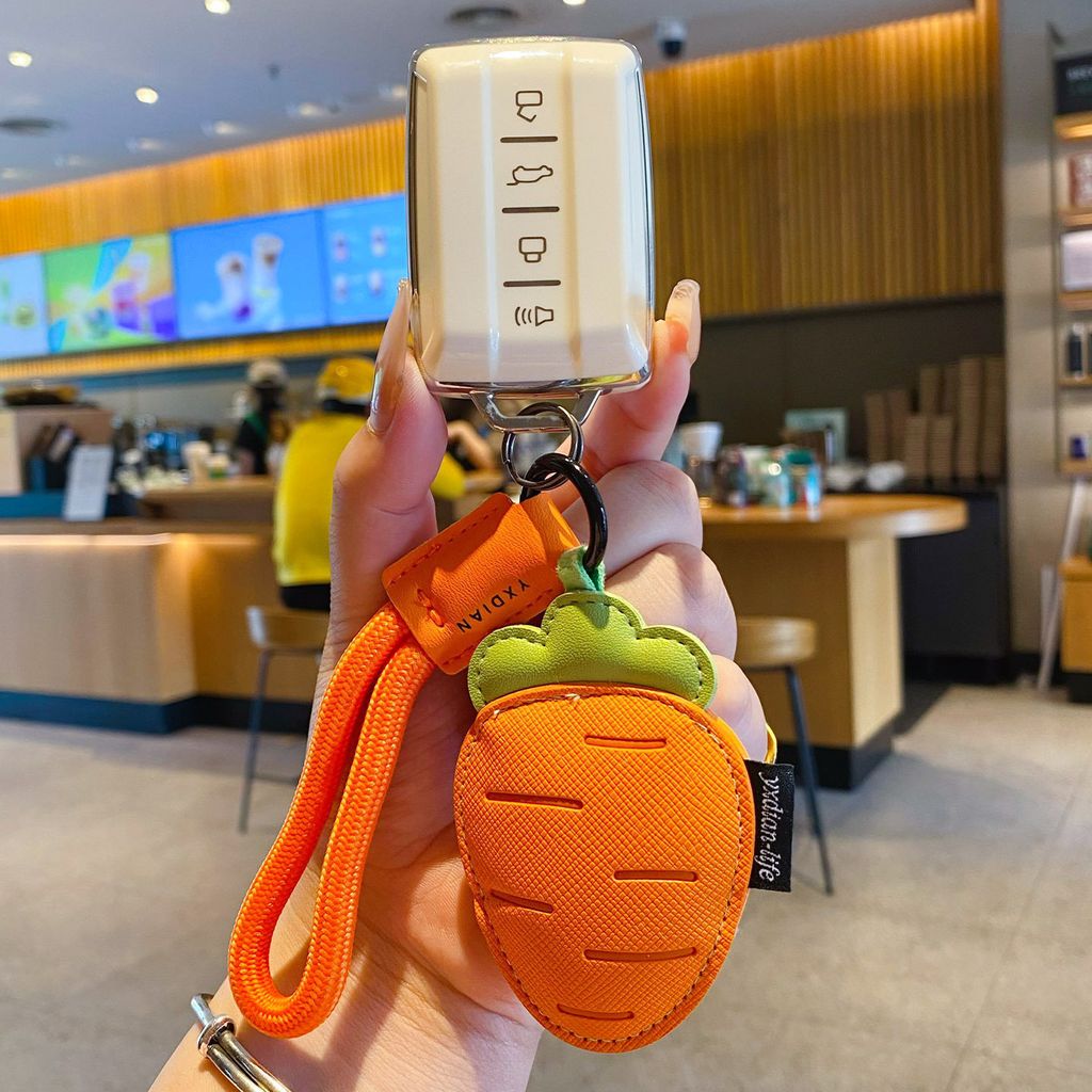 Carrot vegetable leather keychain charm attached to a car key fob