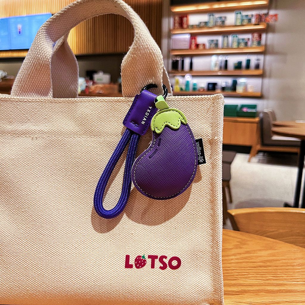 Eggplant vegetable leather keychain charm hanging on a bag