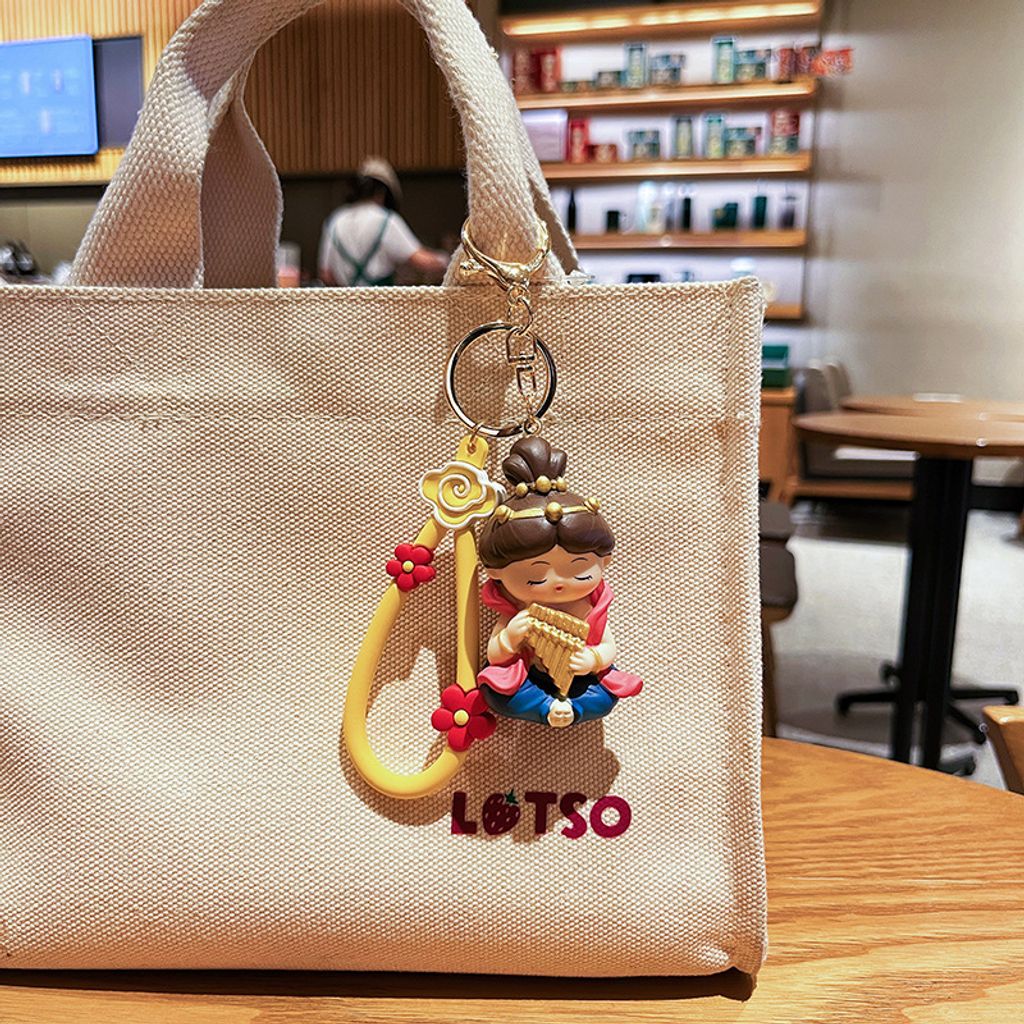 Dunhuang Flying Apsara keychain charm in pan flute style hanging on a bag