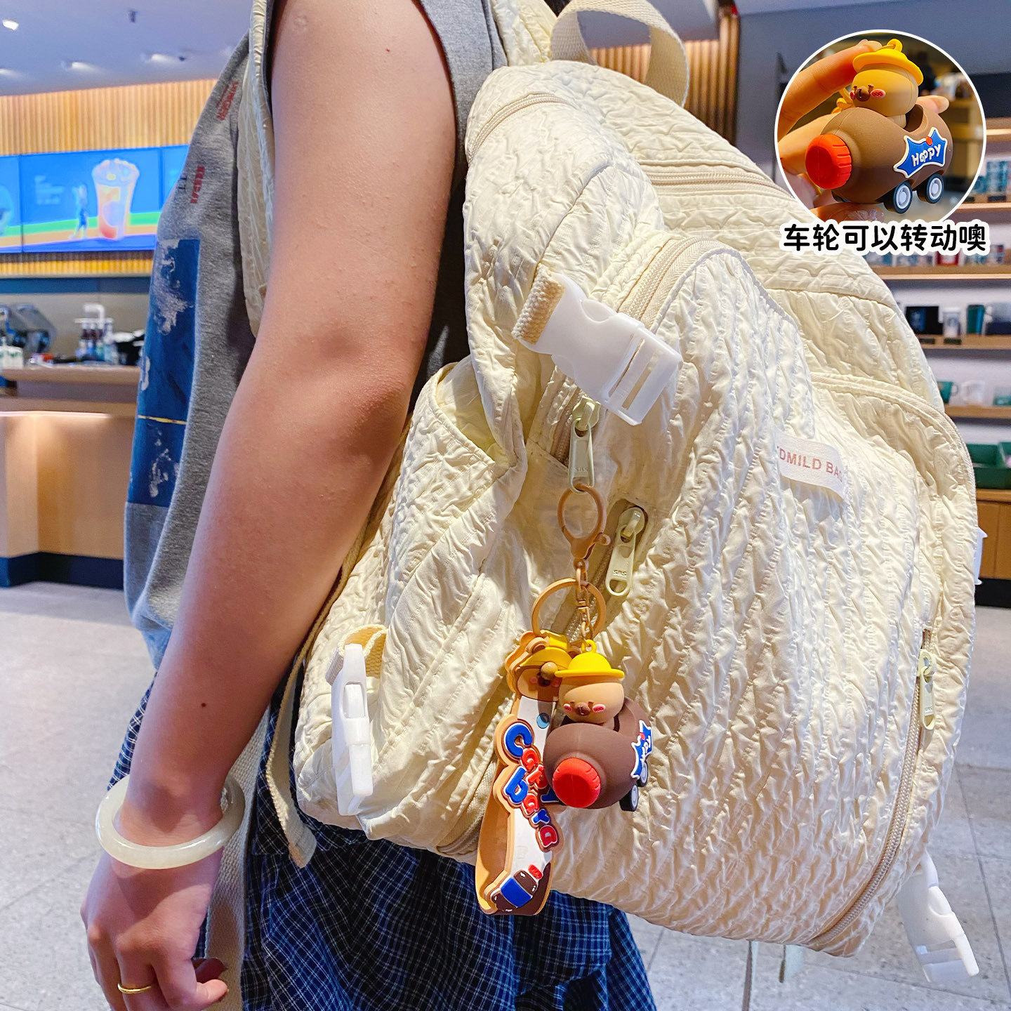 Cute capybara in a brown cola bottle car keychain charm hanging on a bag