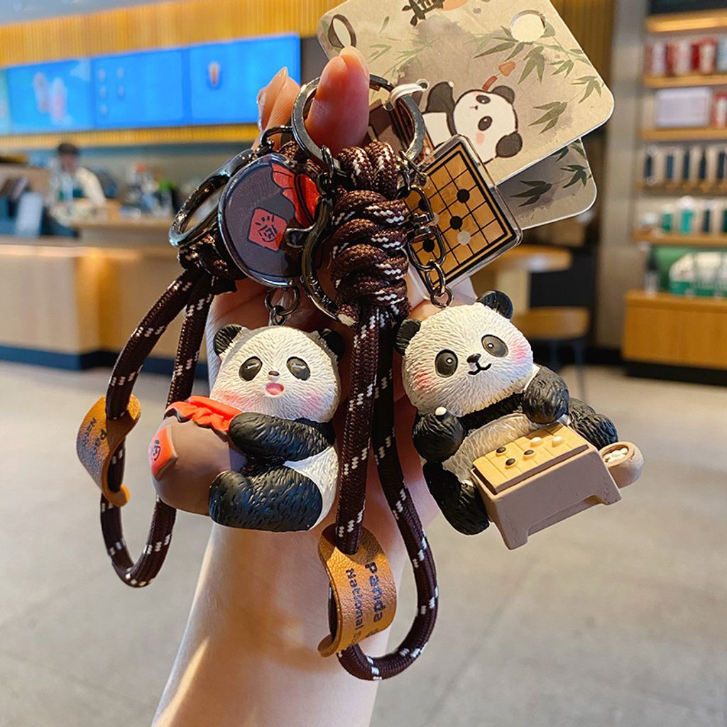 Wine-drinking panda and Go-playing panda keychain charms with traditional refined arts designs