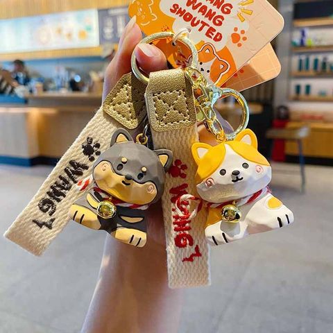 Doberman and Corgi keychain charms in wood carving style