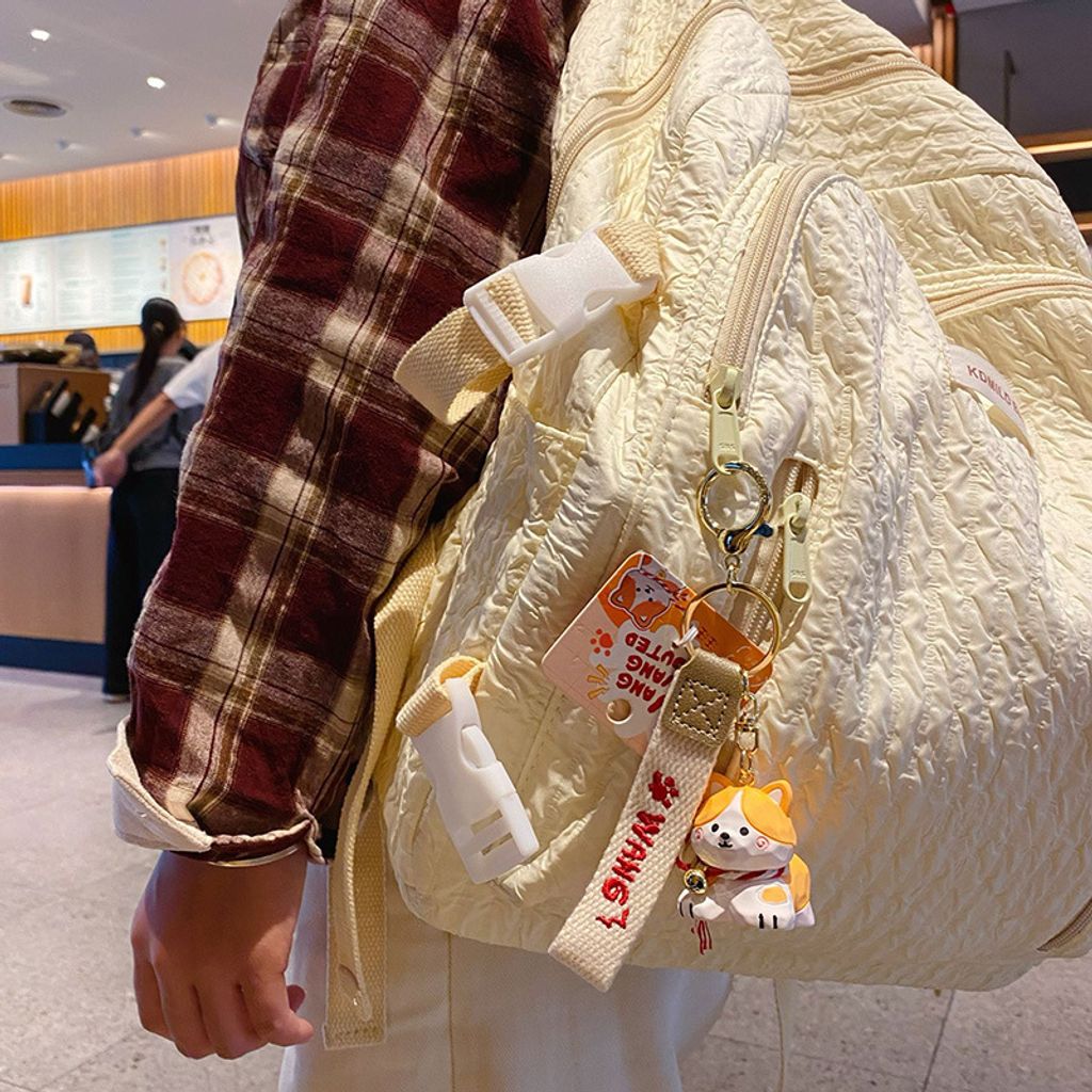 Corgi keychain charm in wood carving style hanging on a bag