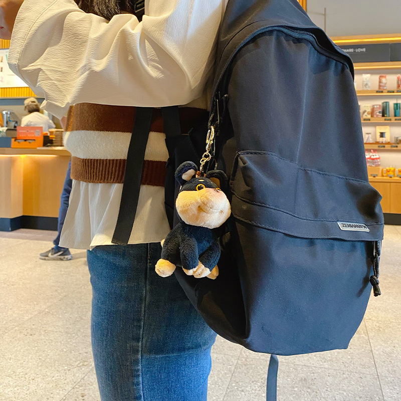 Bee dog plush keychain charm hanging on a bag