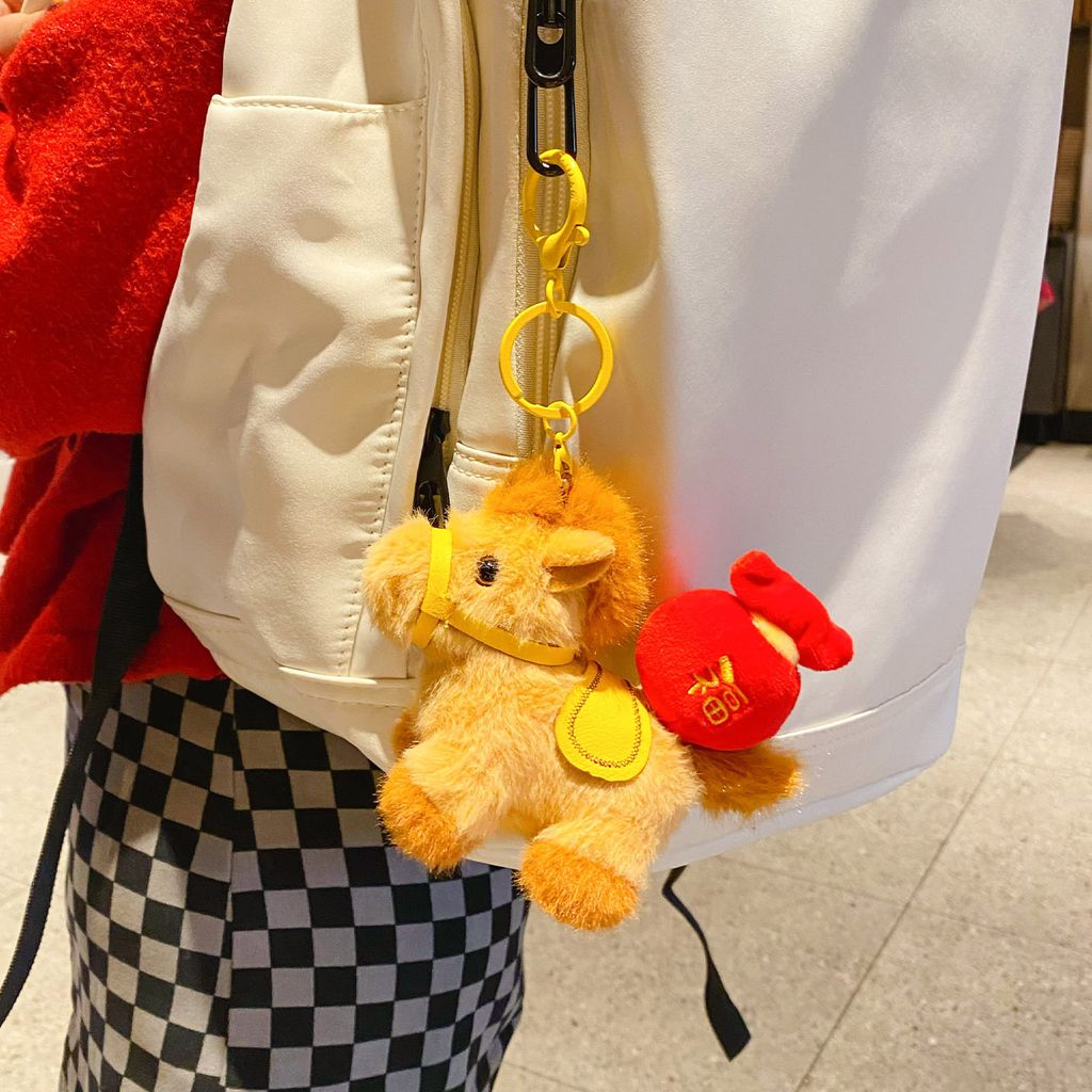 Fortune horse plush keychain charm hanging on a bag