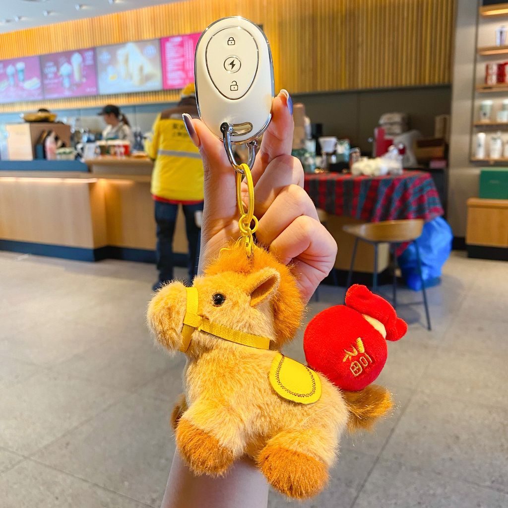 Fortune horse plush keychain charm attached to a car key fob