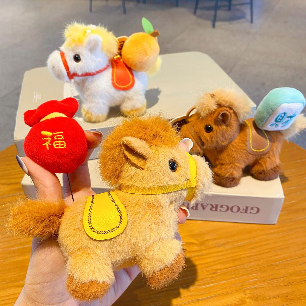 Hand pulling the extendable charm on the fortune horse plush keychain