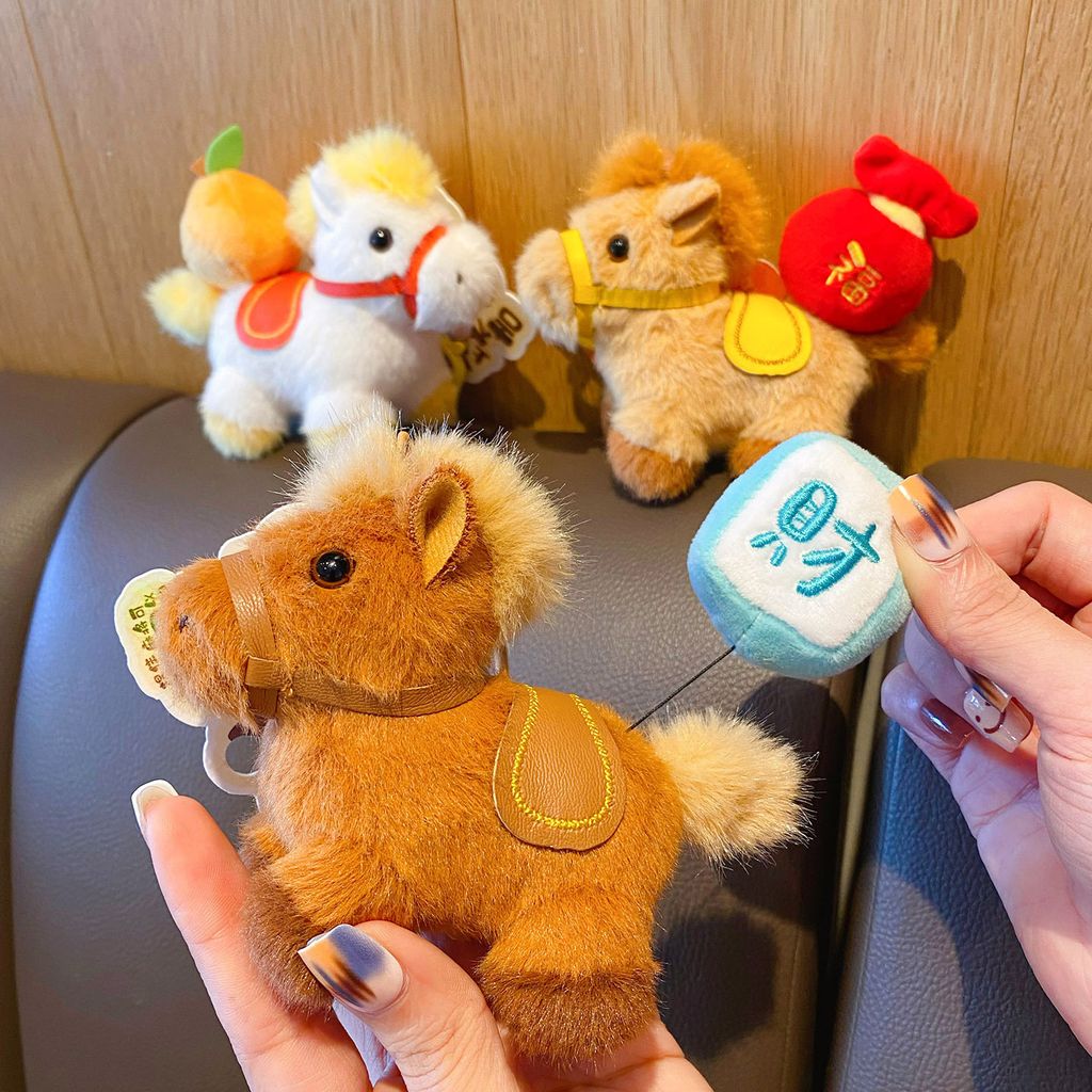 Hand pulling the extendable charm on the prosperity horse plush keychain