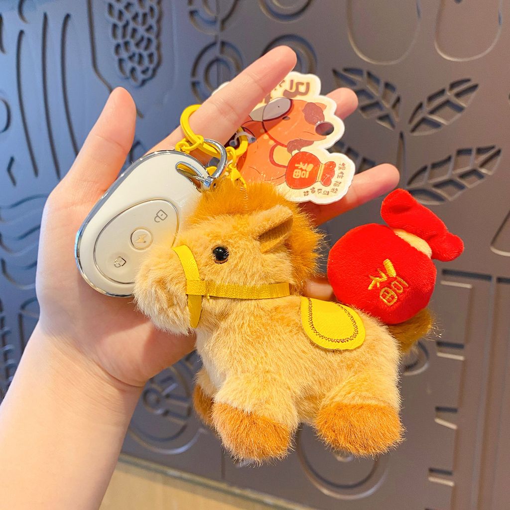 Fortune horse plush keychain charm attached to a car key fob