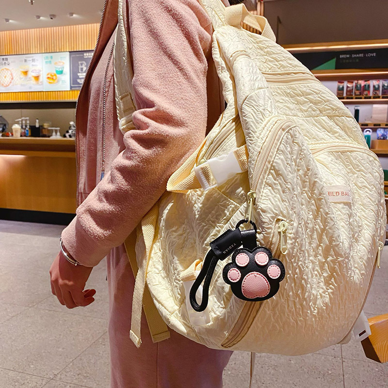 Cute paw leather keychain charm hanging on a bag
