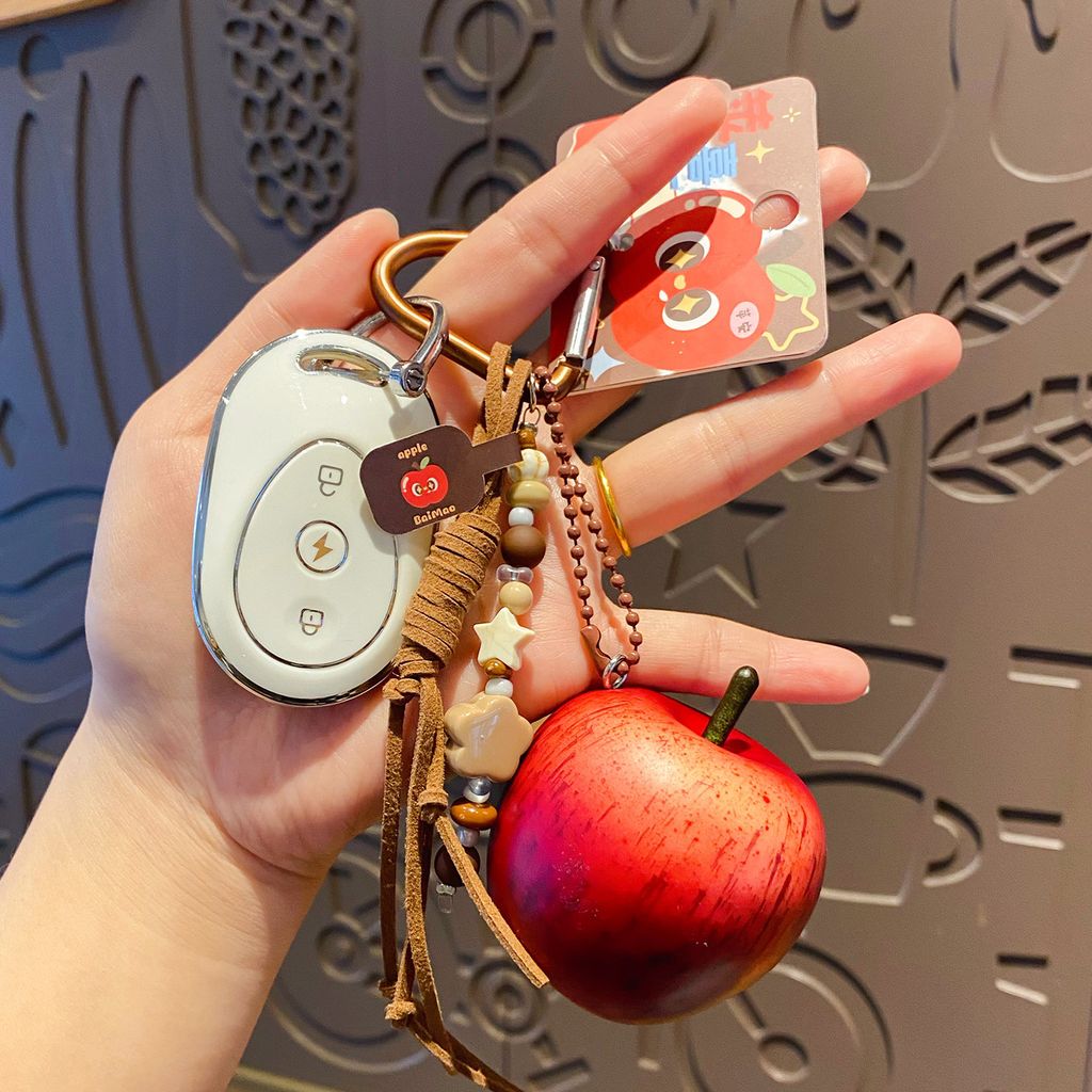 Lucky apple keychain charm attached to a car key fob, red apple design