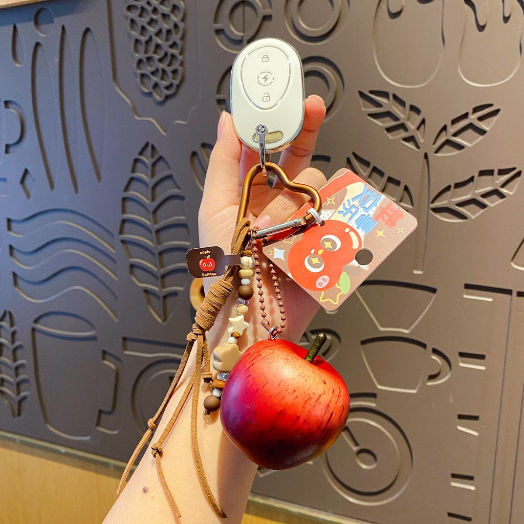 Lucky apple keychain charm attached to a car key fob, red apple design