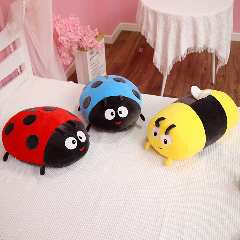 Bee and ladybug plush pillow on bed