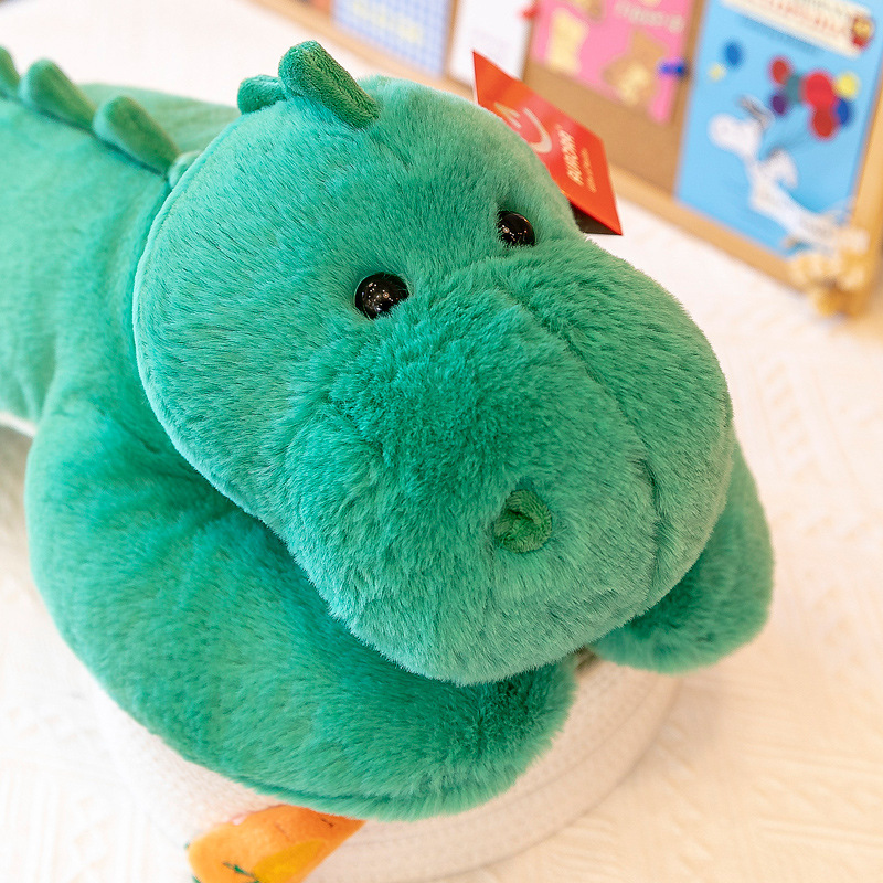 Green dinosaur lying plush toy close up